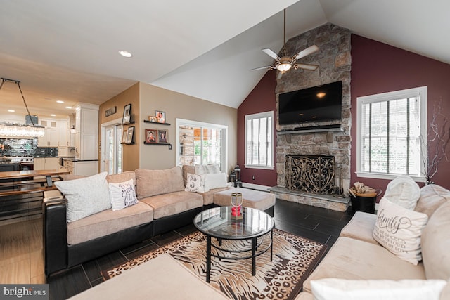 living room with a fireplace, ceiling fan, dark hardwood / wood-style floors, and lofted ceiling