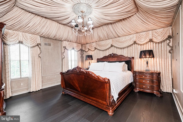 bedroom with dark hardwood / wood-style flooring, a chandelier, and multiple windows