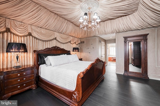 bedroom with dark hardwood / wood-style flooring and an inviting chandelier