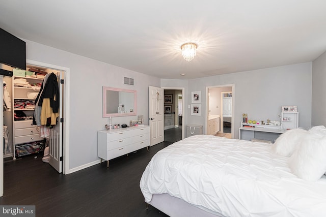 bedroom featuring a closet, dark hardwood / wood-style flooring, a walk in closet, and ensuite bath