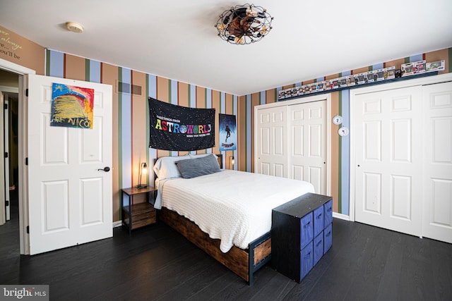 bedroom featuring dark hardwood / wood-style floors and two closets