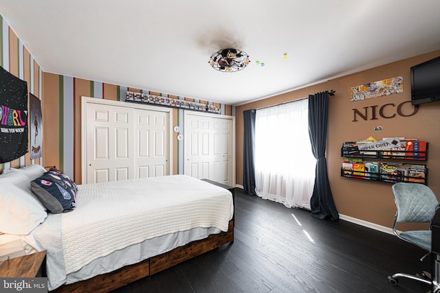 bedroom featuring dark hardwood / wood-style flooring and two closets