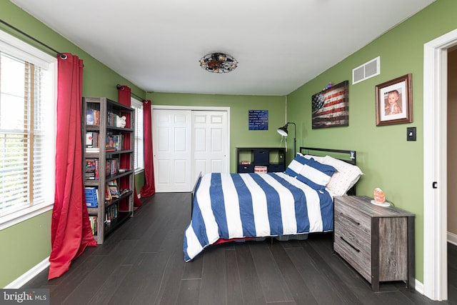 bedroom featuring multiple windows, a closet, and dark hardwood / wood-style floors