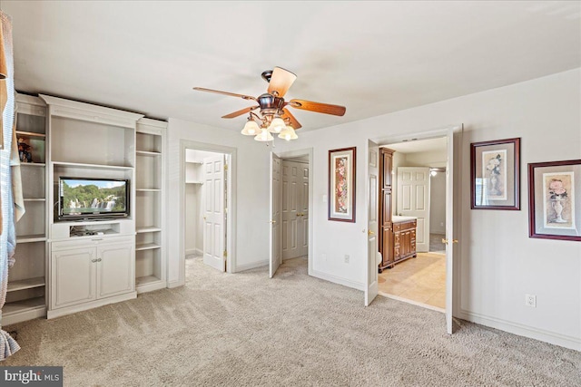 unfurnished bedroom featuring light colored carpet, ceiling fan, and ensuite bathroom