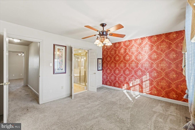 unfurnished bedroom featuring light carpet, ensuite bathroom, and ceiling fan