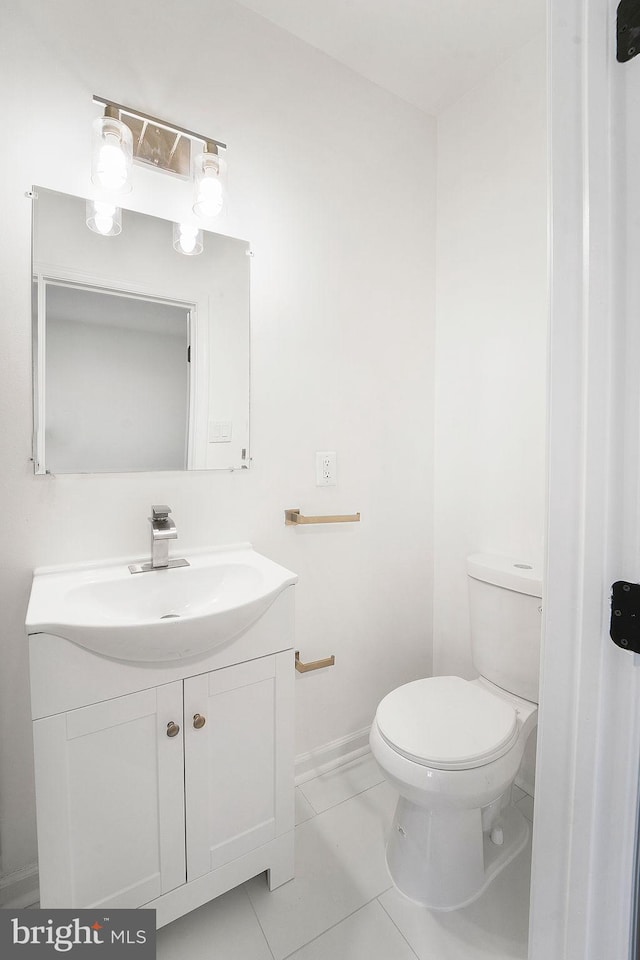 bathroom with toilet, tile patterned flooring, and vanity