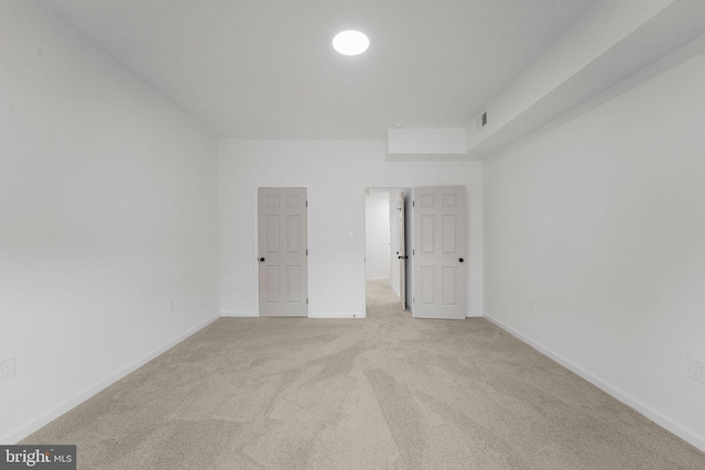 unfurnished room featuring light carpet