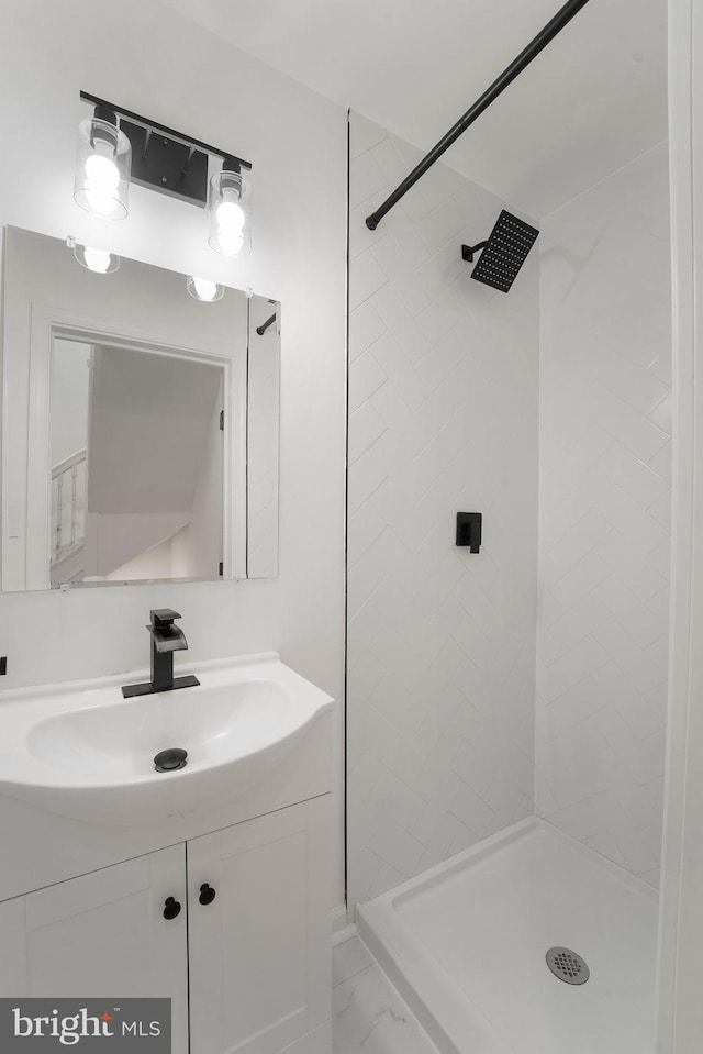 bathroom with vanity and a tile shower