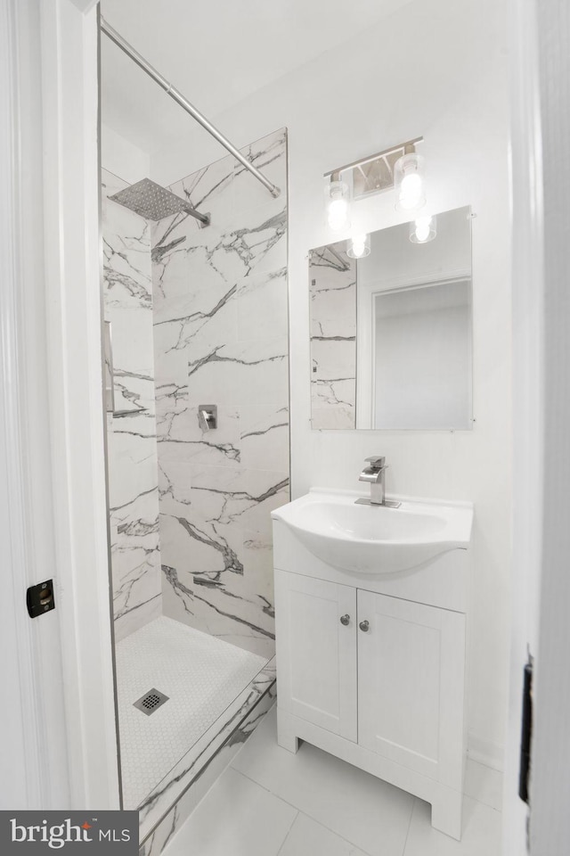 bathroom with vanity, tiled shower, and tile patterned flooring