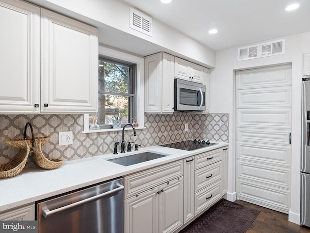 kitchen with dark wood-type flooring, sink, white cabinets, and stainless steel appliances