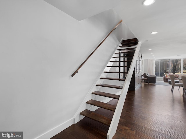 stairs featuring wood-type flooring and a wall of windows