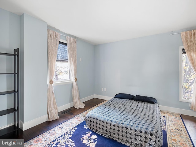 bedroom featuring multiple windows and dark hardwood / wood-style floors