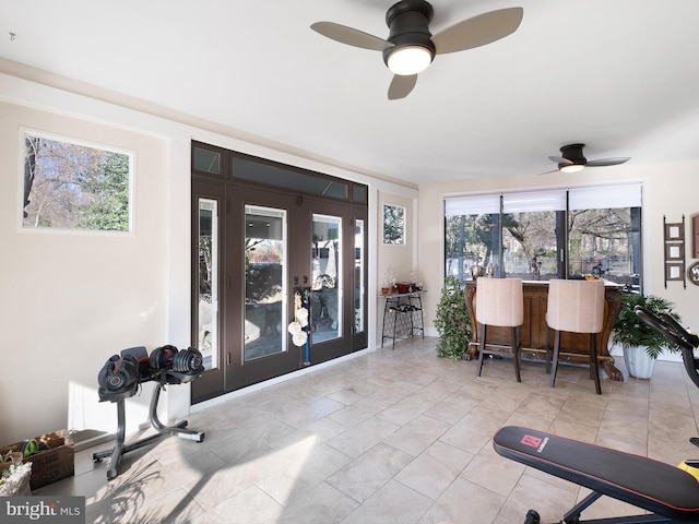 sunroom / solarium featuring indoor bar and ceiling fan