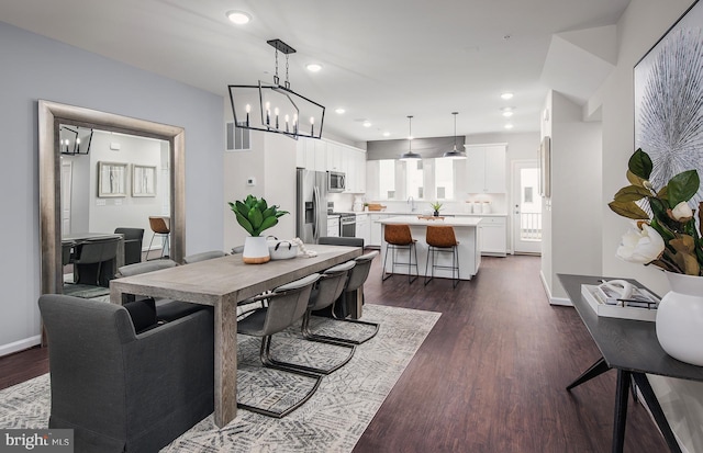 dining space with dark hardwood / wood-style floors and a chandelier