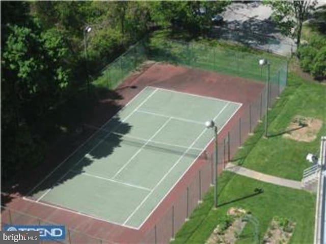 view of tennis court featuring a lawn