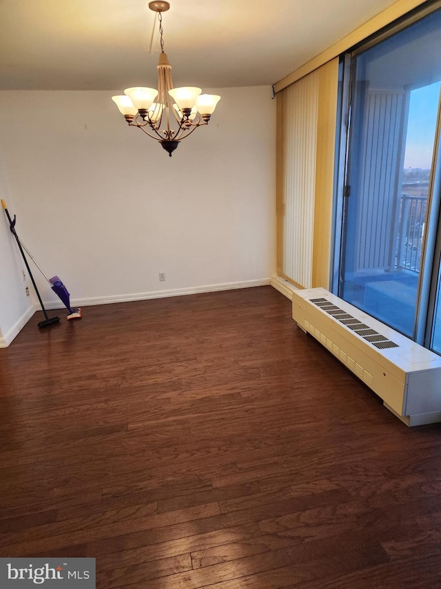 unfurnished room with dark hardwood / wood-style flooring and a chandelier