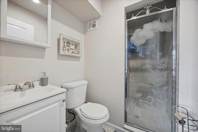 bathroom with vanity, toilet, and a shower with shower door