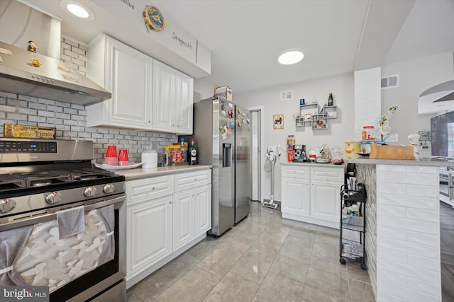 kitchen with decorative backsplash, white cabinetry, wall chimney range hood, and stainless steel appliances