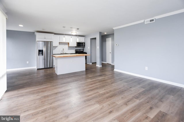 kitchen featuring butcher block counters, hardwood / wood-style floors, white cabinets, and appliances with stainless steel finishes