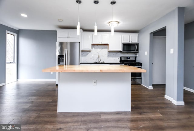 kitchen with stainless steel appliances, hanging light fixtures, white cabinets, butcher block countertops, and dark hardwood / wood-style floors