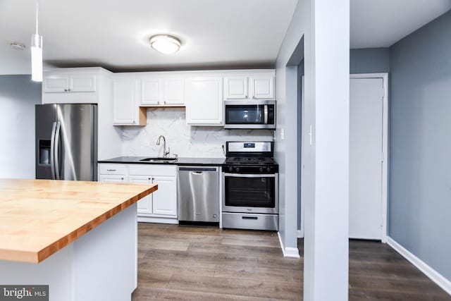 kitchen featuring butcher block counters, white cabinetry, sink, and appliances with stainless steel finishes