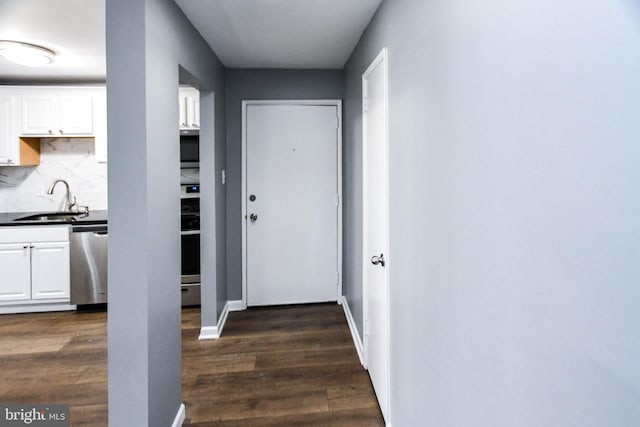 doorway to outside with sink and dark wood-type flooring