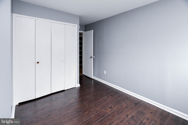 unfurnished bedroom featuring dark hardwood / wood-style floors and a closet