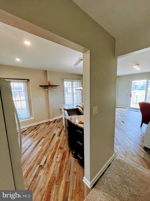 corridor with a healthy amount of sunlight and light hardwood / wood-style flooring