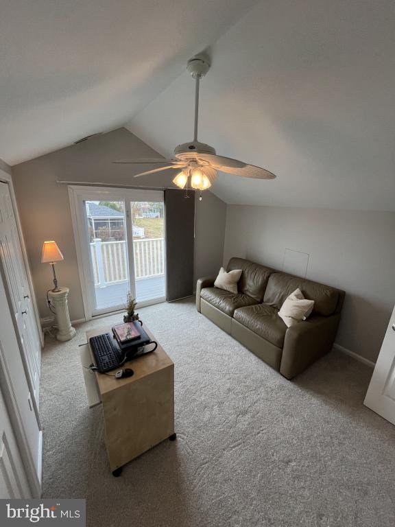 carpeted living room featuring ceiling fan and lofted ceiling