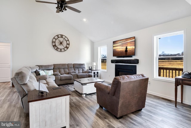 living room featuring ceiling fan, wood-type flooring, and high vaulted ceiling