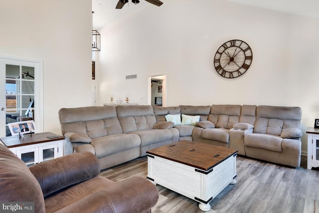 living room with hardwood / wood-style floors, high vaulted ceiling, and ceiling fan