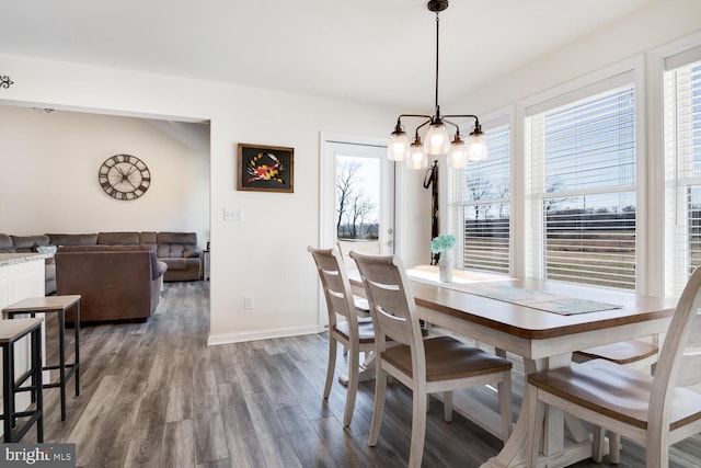 dining area with wood-type flooring, an inviting chandelier, and plenty of natural light