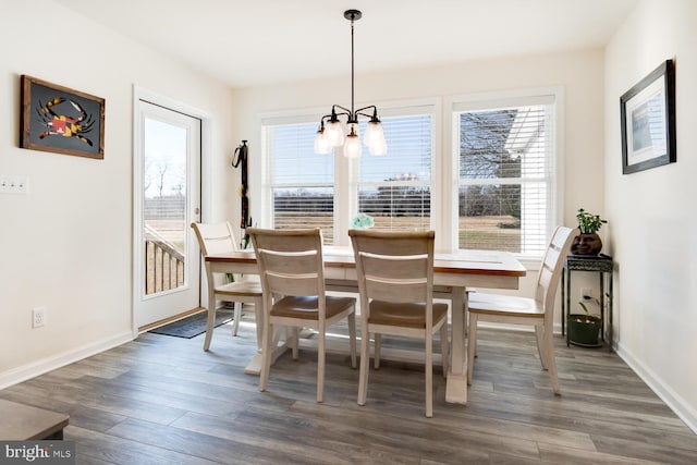 dining room featuring an inviting chandelier, plenty of natural light, and dark wood-type flooring