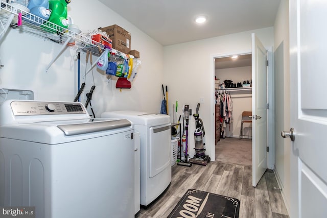 clothes washing area featuring light hardwood / wood-style floors and washing machine and dryer