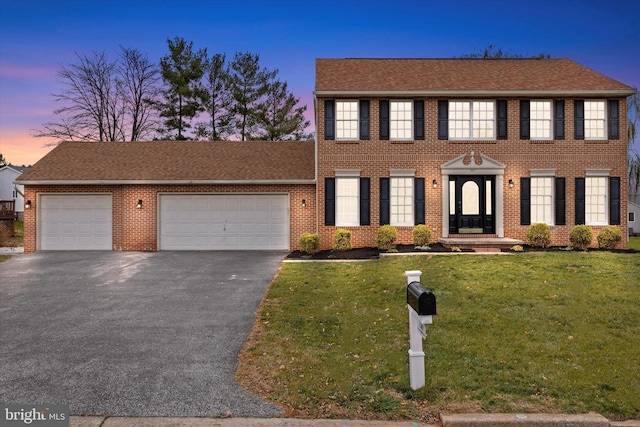 colonial-style house with a lawn and a garage