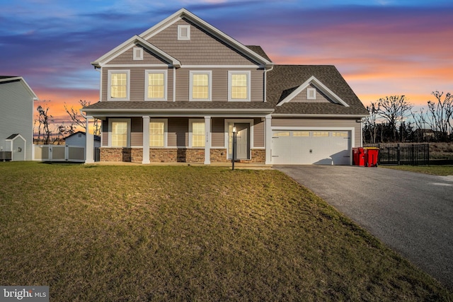 craftsman-style home with a garage, covered porch, and a yard