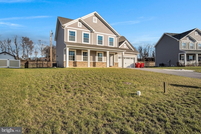 craftsman-style house with covered porch, a garage, and a front lawn