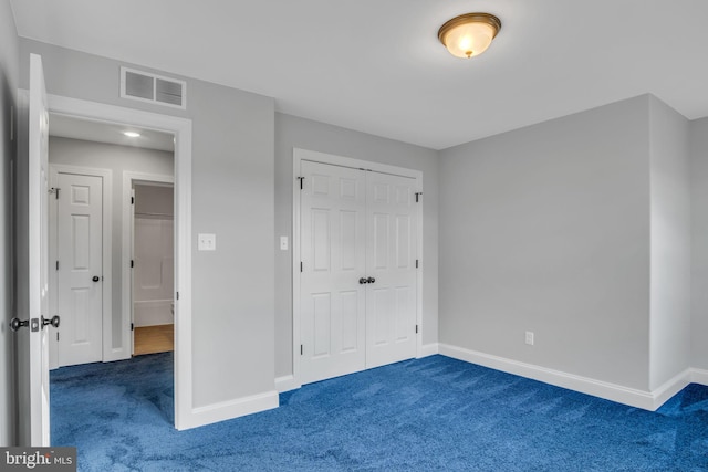 unfurnished bedroom featuring a closet and dark carpet