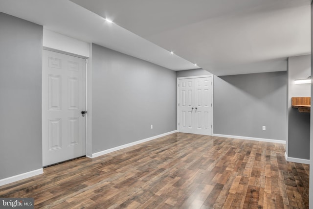 basement with dark hardwood / wood-style flooring