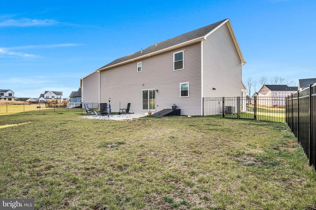 rear view of property with a yard, cooling unit, and a patio