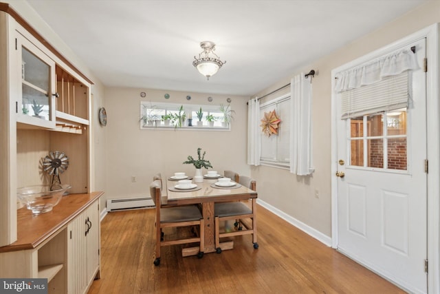 dining area featuring light hardwood / wood-style floors and a baseboard heating unit