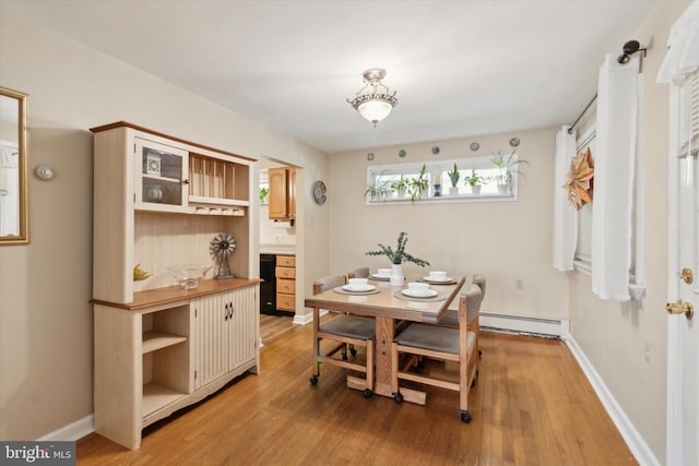 dining space featuring baseboard heating and light wood-type flooring