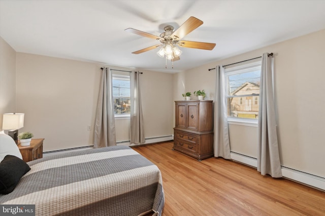 bedroom featuring light wood-type flooring, a baseboard radiator, and ceiling fan