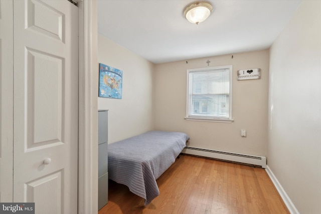 bedroom featuring light hardwood / wood-style floors and a baseboard radiator