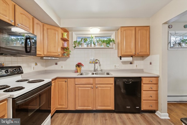 kitchen with black appliances, plenty of natural light, sink, and light hardwood / wood-style flooring