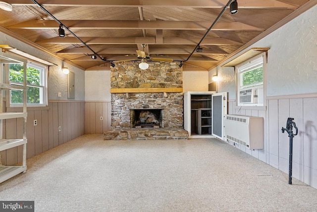 unfurnished living room with vaulted ceiling with beams, wood ceiling, a fireplace, and heating unit