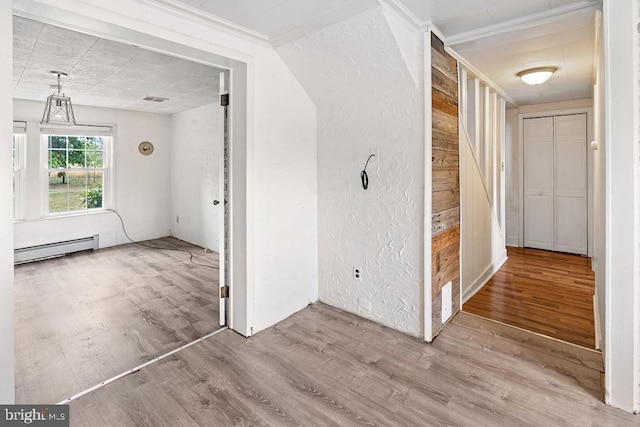 hall with light hardwood / wood-style floors and a baseboard heating unit