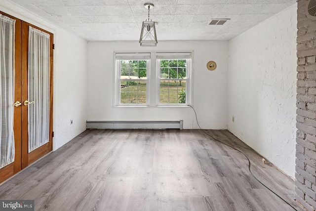 spare room with french doors, a baseboard radiator, and light wood-type flooring