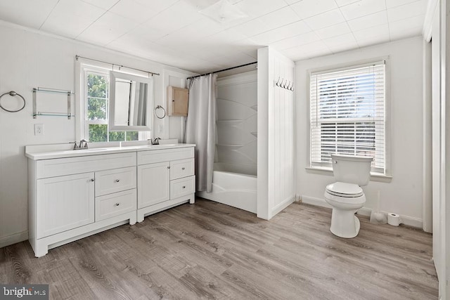 full bathroom featuring hardwood / wood-style floors, vanity, a healthy amount of sunlight, and shower / tub combo with curtain