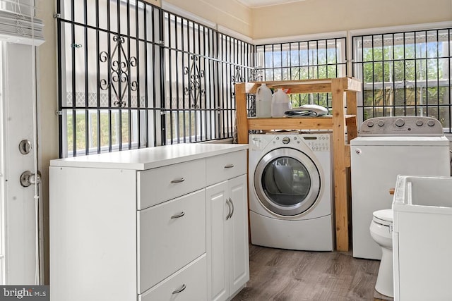 laundry room with independent washer and dryer, sink, plenty of natural light, and hardwood / wood-style floors